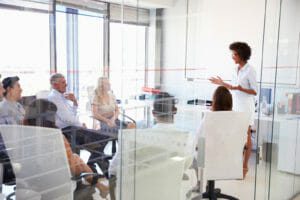 Woman giving presentation to small group in office