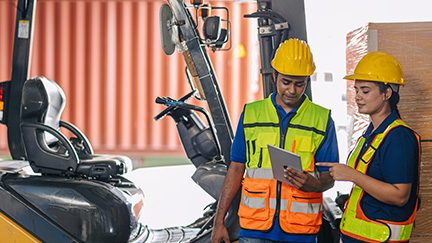 Two young people working around heavy equipment