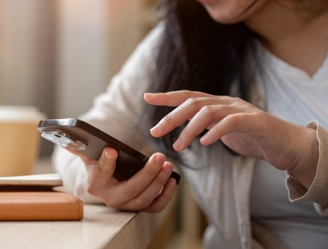 Woman holding a cell phone, about to type in a number to make a call