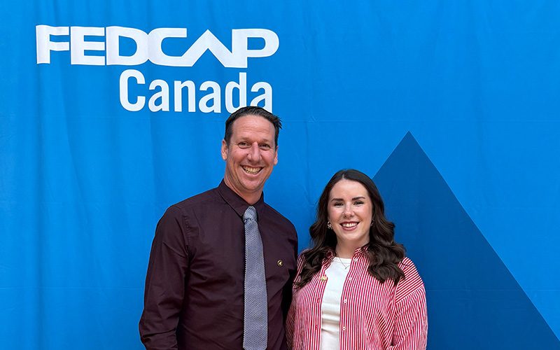 FedCap_Awards Cam and Justine standing in front of FedCap backdrop.